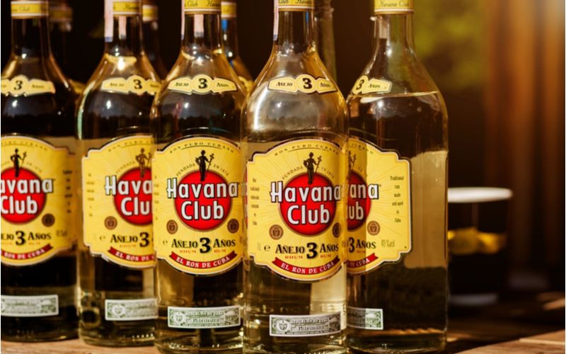 Bílé rumy - Havana Club Aňejo 3y, zástup lahví na polici