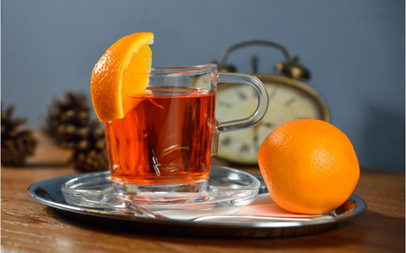 Horký Aperol Spritz nápoj ve sklenici s pomerančem