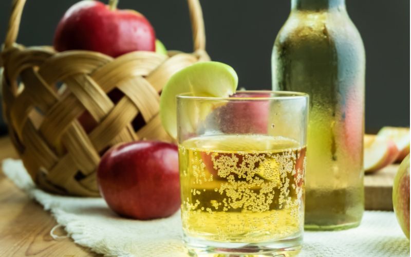 Domácí cider v láhvi a ve sklenici, jablka