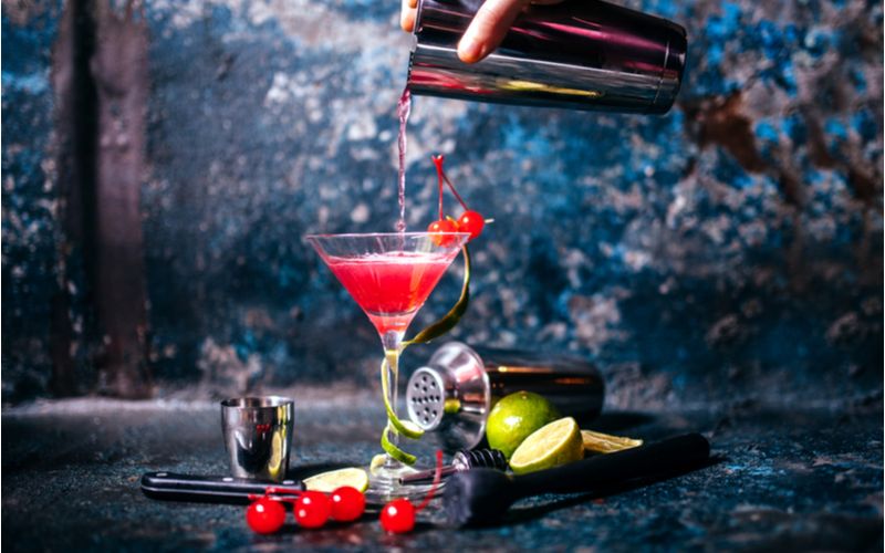 Cosmopolitan koktejl, barman nalévá do sklenice na Martini