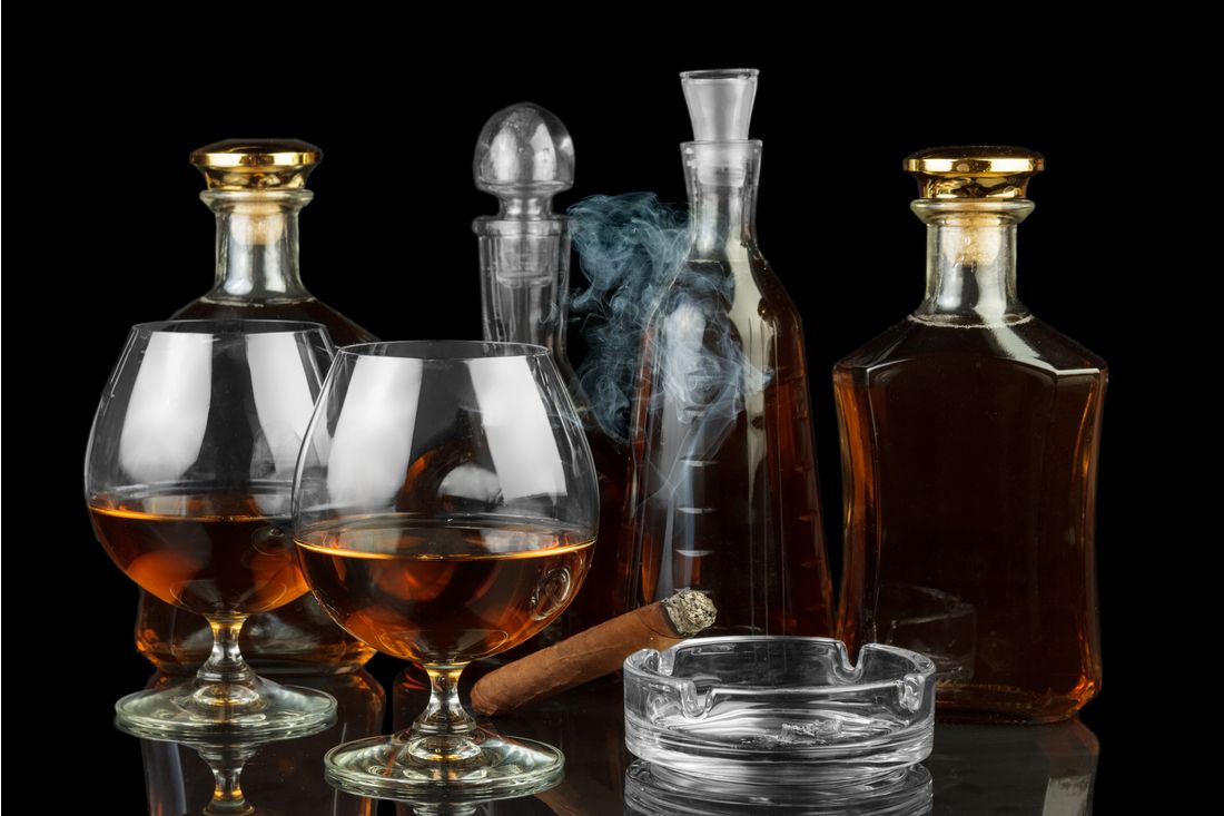 Láhve s luxusním alkoholem, sklenice a doutník