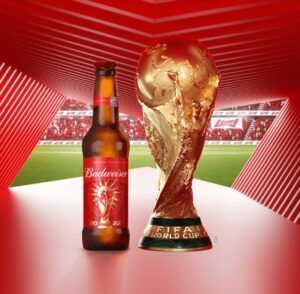 Budweiser - generální partner MS 2022 v Kataru - reklamní poster: láhev piva vedle vítězné trofeje