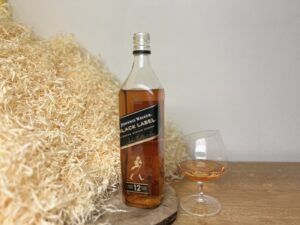 Johnnie Walker Black Label - degustace, láhev a sklenice s alkoholem vedle