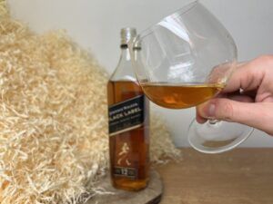 Johnnie Walker Black Label - degustace, láhev a sklenice s alkoholem vedle