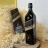 Johnnie Walker Double Black - celá láhev na dřevěném podnosu a v pozadí karton