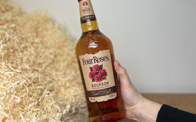 Four Roses Bourbon - láhev alkoholu v ruce