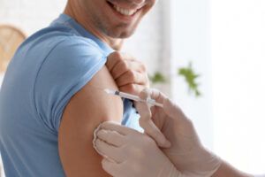 Muž během očkování, dostává injekci do ramene