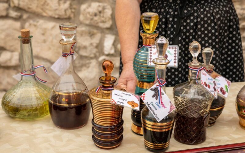 Rakija - kolekce různých ovocných balkánských destilátů v typické karafě