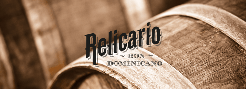 Relicario Ron Dominicano - logo značky na pozadí dřevěných sudů
